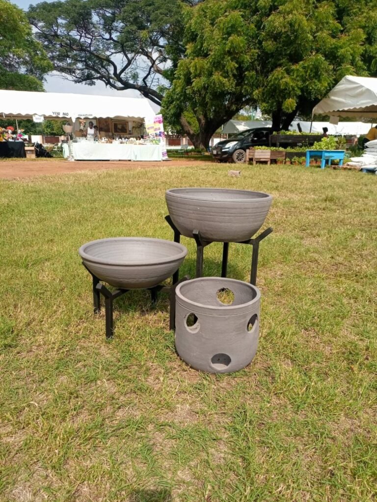Grey stone bowl planters and a cut-out cylinder pot on grass