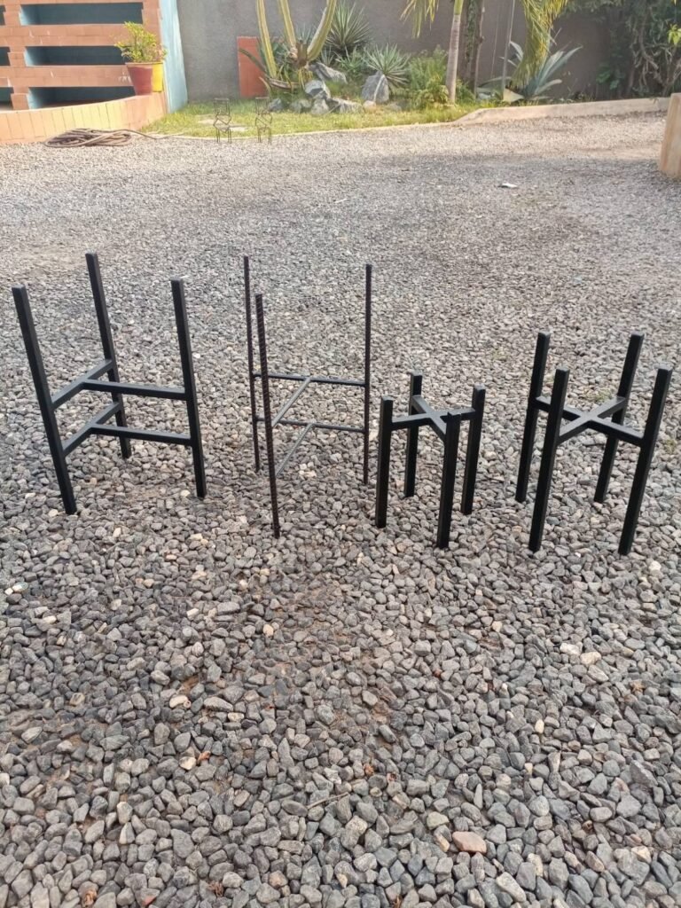 Four black four-leg metal pot stands in different sizes