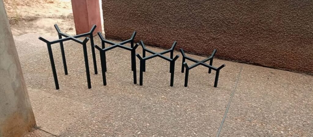 Four low cross-top metal pot stands in graduated sizes